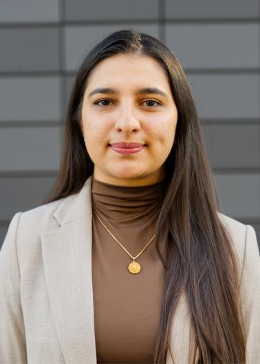 Photograph of a woman, Mishal Kahn, wearing a brown top and a beige blazer.
